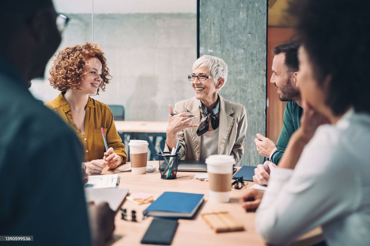 Group of business people sitting around a table and talking