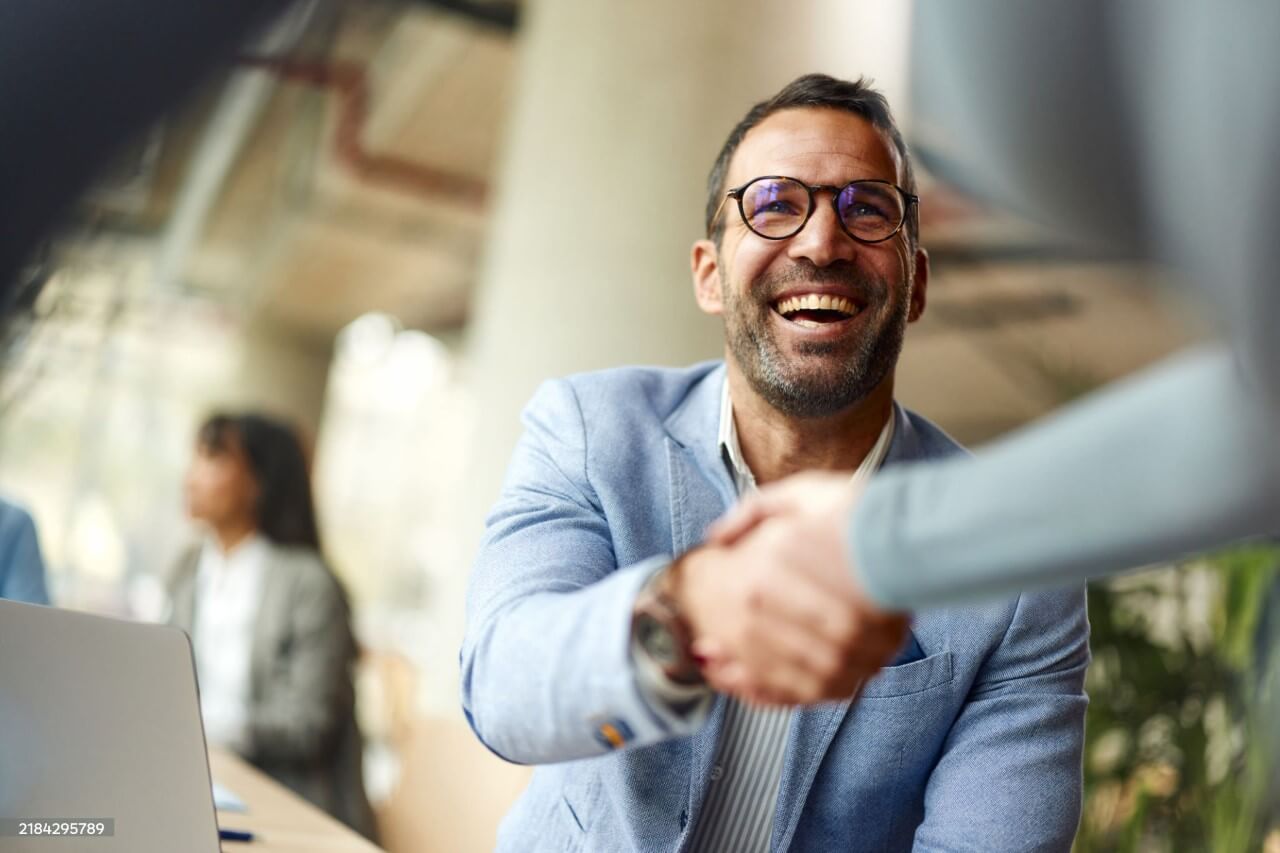 Entrepreneur greeting his colleague while working in the office